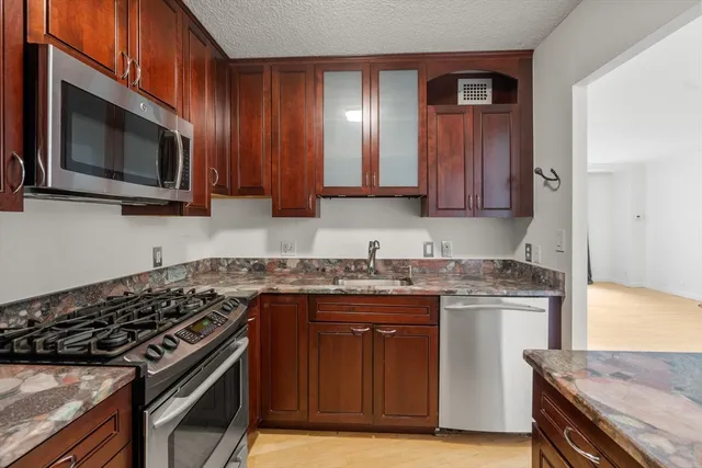 a kitchen with stainless steel appliances granite countertop a stove microwave and cabinets