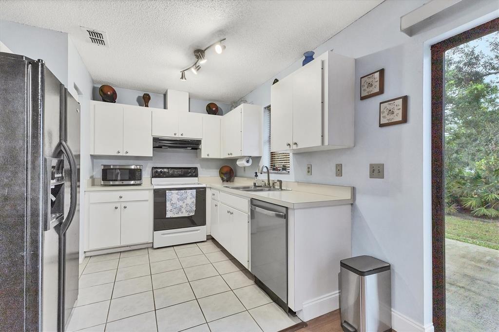 7109 Java Drive Sarasota, FL 34241 - Photo 12 of 23 a kitchen with white cabinets and white appliances