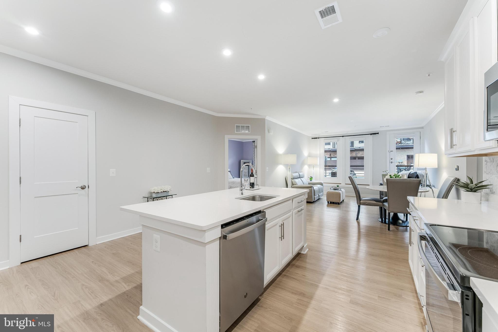 1675 Bandit Loop, Unit 105B Reston, VA 20190 - Photo 7 of 27 a large kitchen with a large counter top a sink stainless steel appliances and cabinets