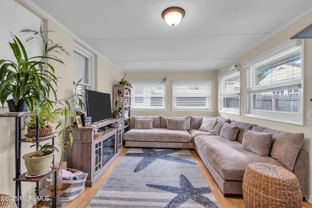 a living room with furniture a flat screen tv and a large window