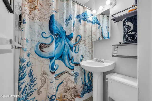 a bathroom with a sink and mirror with bathtub