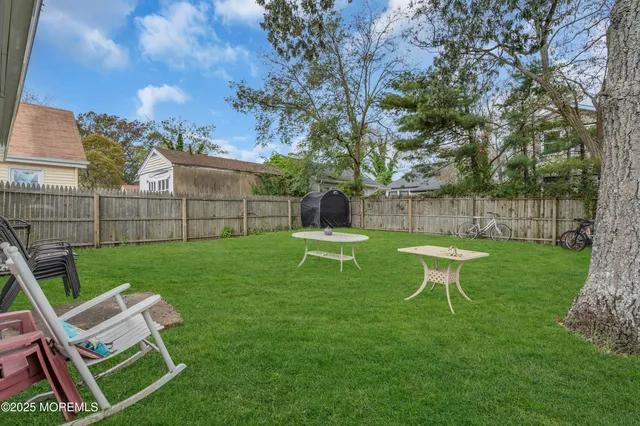 a view of a chair and table in backyard of the house