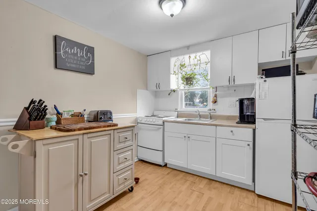a kitchen with white cabinets and white appliances