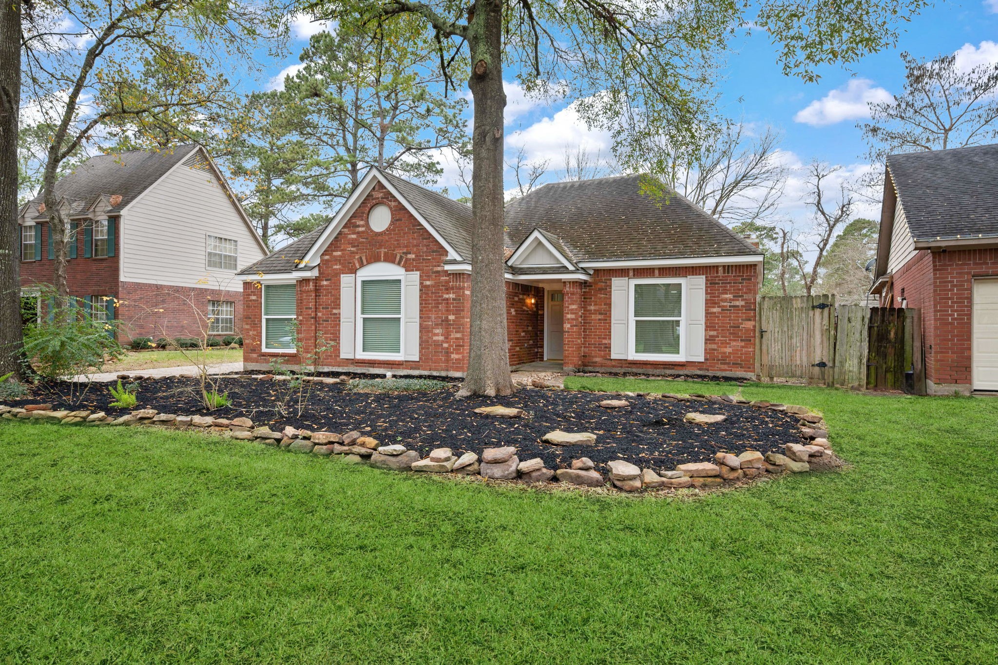 5411 Shady Maple Drive Houston, TX 77339 - Photo 3 of 28 Charming single-story brick home with a well-maintained front yard featuring mature trees and a landscaped garden bed. The property exudes curb appeal with its white-trimmed windows and inviting entrance.
