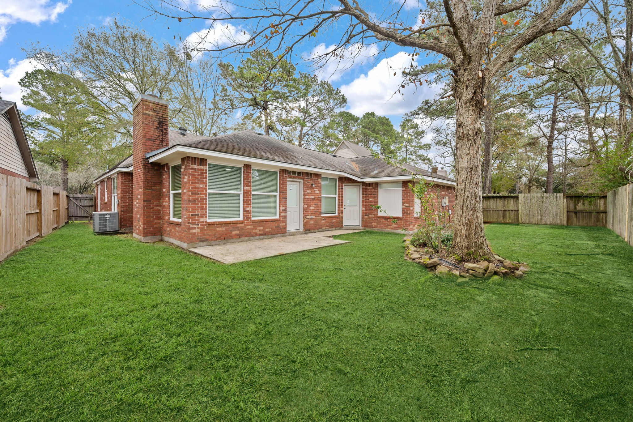 5411 Shady Maple Drive Houston, TX 77339 - Photo 5 of 28 Charming brick home with a spacious fenced backyard, featuring a large tree and patio area. Ideal for outdoor activities and relaxation.