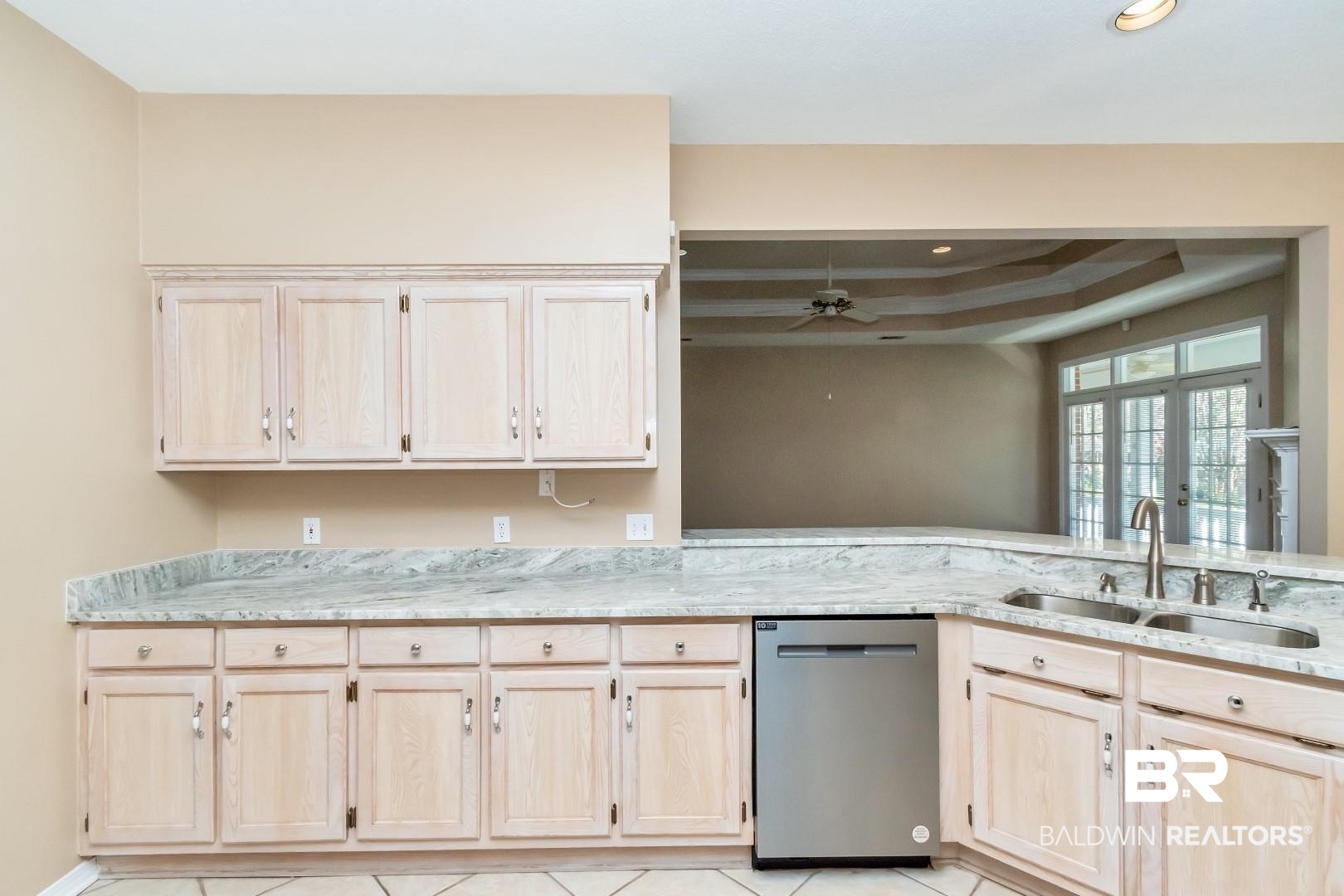 6117 Lennox Place Mobile, AL 36693 - Photo 17 of 39 Kitchen with stainless steel dishwasher, a sink, light brown cabinetry, and a tray ceiling