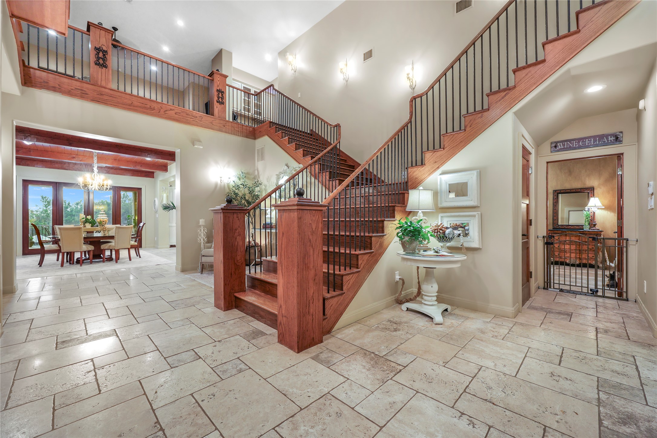 17501 Navigation Lane Lago Vista, TX 78645 - Photo 7 of 40 Entryway featuring a grand staircase with dark wood treads and wrought iron balusters, a second-story landing with matching railings, and light-colored tile flooring