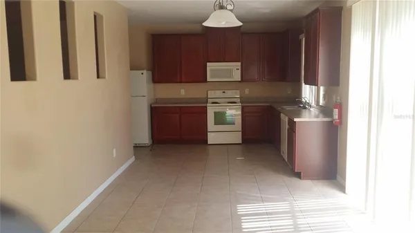 a kitchen with stainless steel appliances granite countertop a refrigerator a stove and a sink