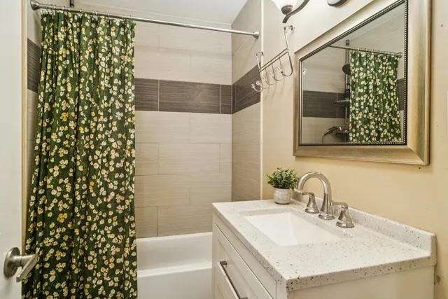 a bathroom with a granite countertop sink and a shower