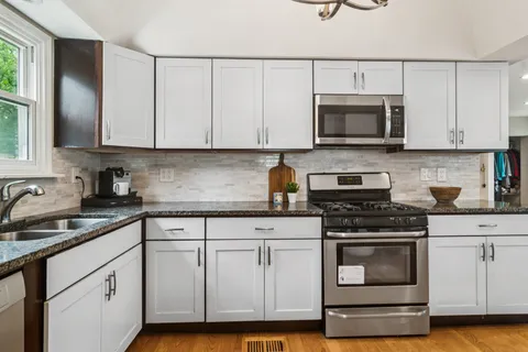 a kitchen with white cabinets and appliances