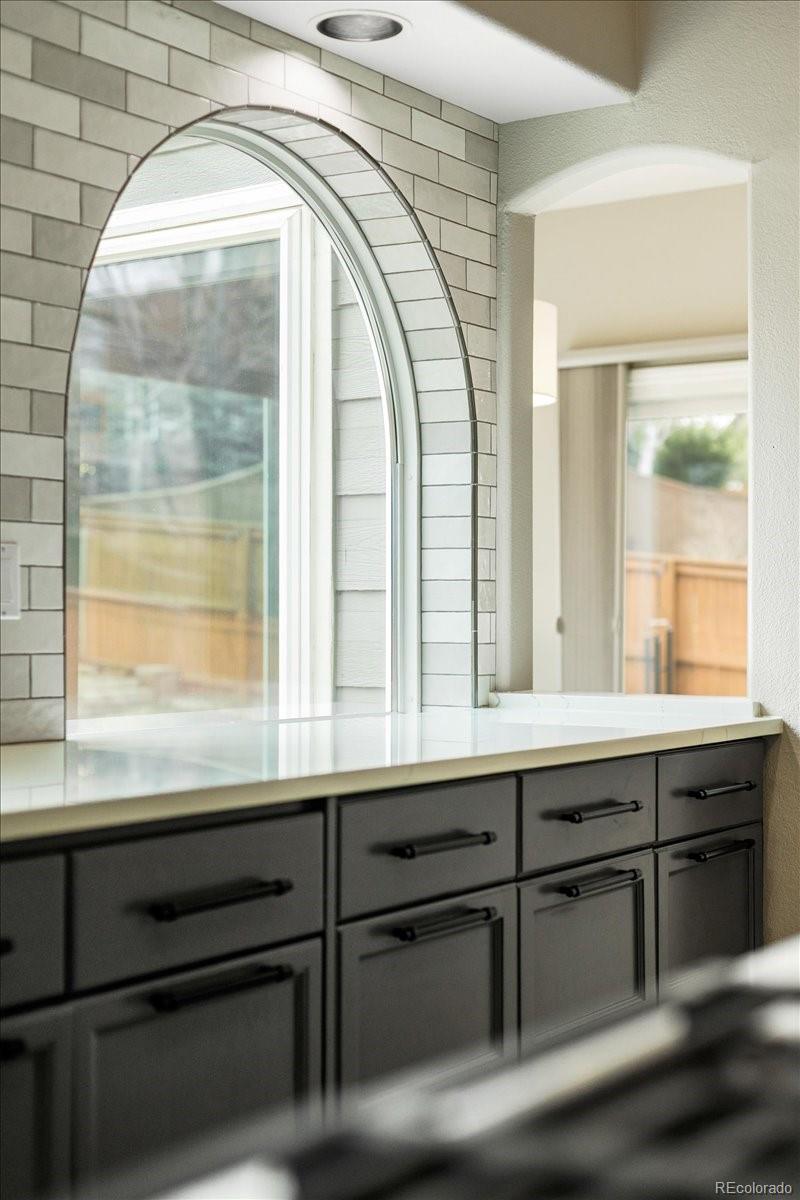 3385 White Oak Lane Highlands Ranch, CO 80129 - Photo 12 of 36 a bathroom with a sink a vanity and a large mirror next to a window