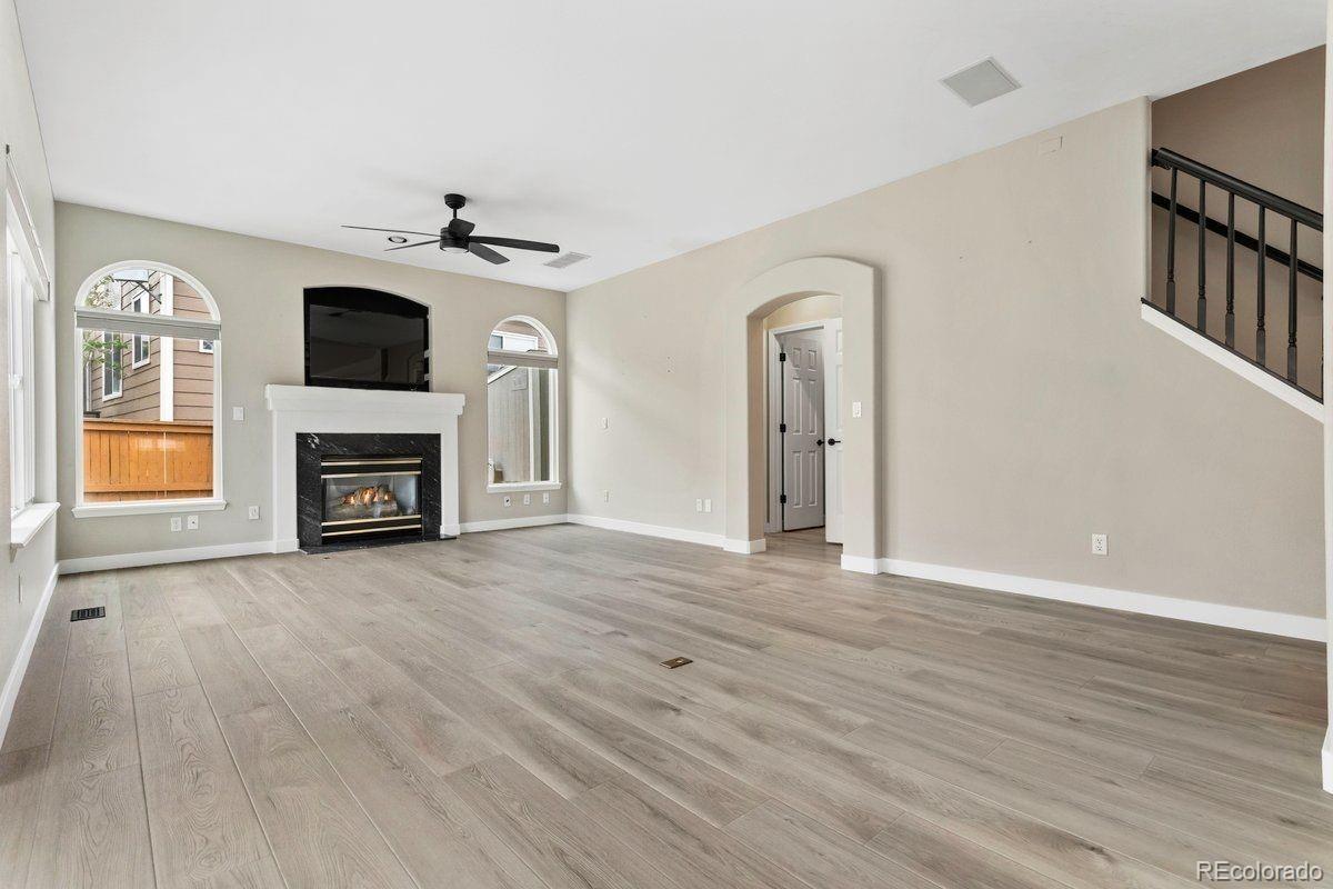 3385 White Oak Lane Highlands Ranch, CO 80129 - Photo 16 of 36 wooden floor fireplace and natural light in living room