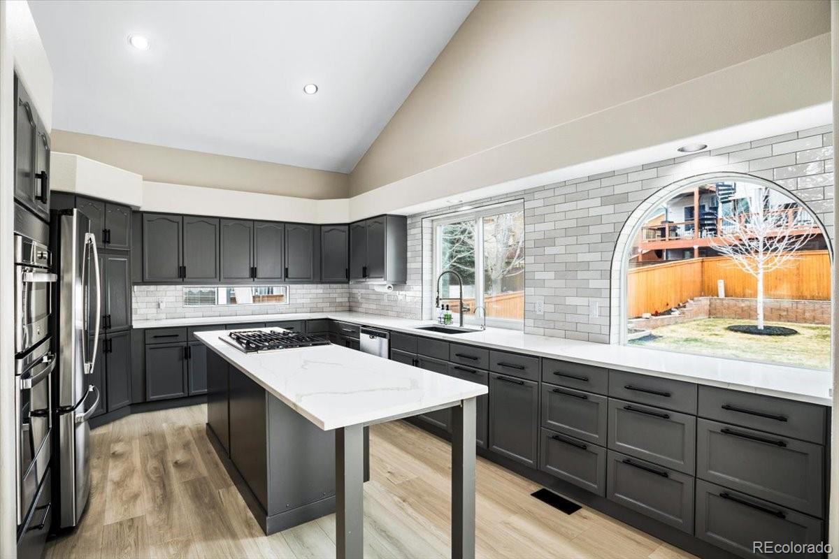 3385 White Oak Lane Highlands Ranch, CO 80129 - Photo 8 of 36 a kitchen with a sink a stove a refrigerator and a oven