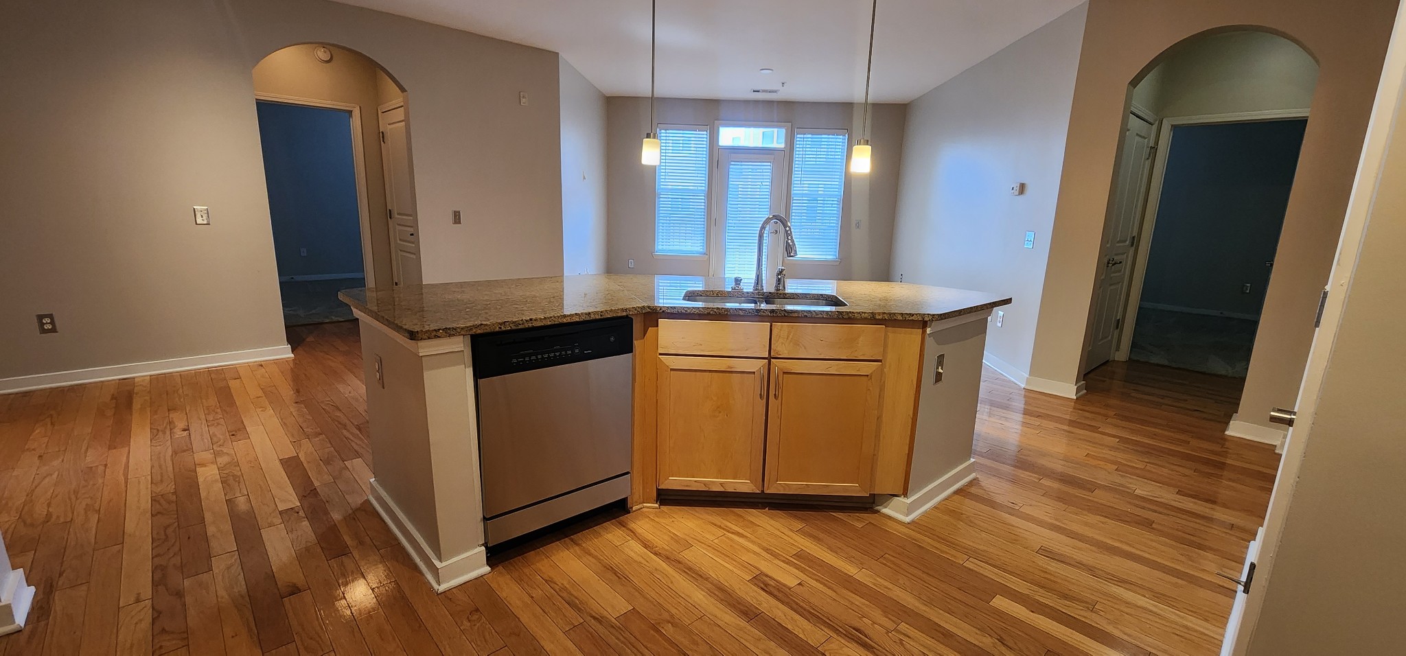 a kitchen with a sink and wooden floor
