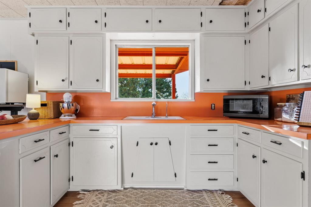 910 South Harrison Street West, TX 76691 - Photo 17 of 39 a kitchen with white cabinets and window