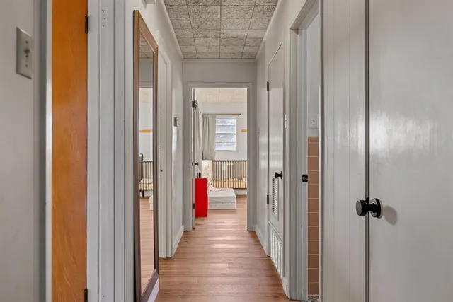 a view of a hallway with wooden floor and closet