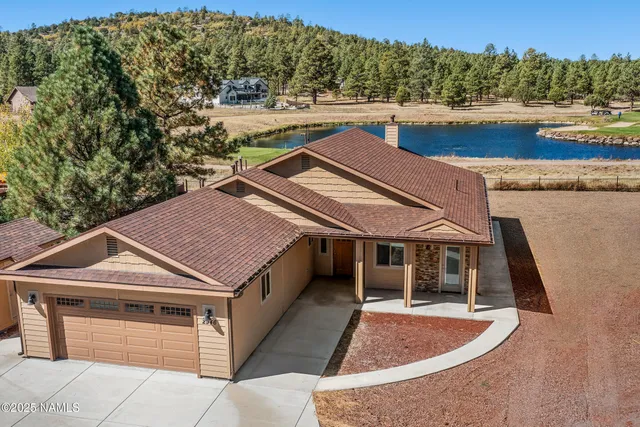 a aerial view of a house with swimming pool and large trees