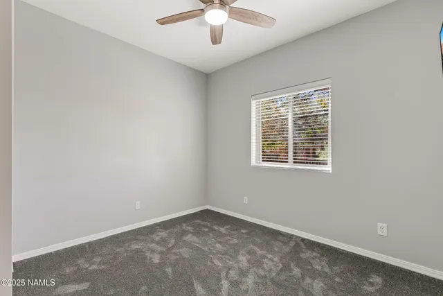 an empty room with a window and a ceiling fan