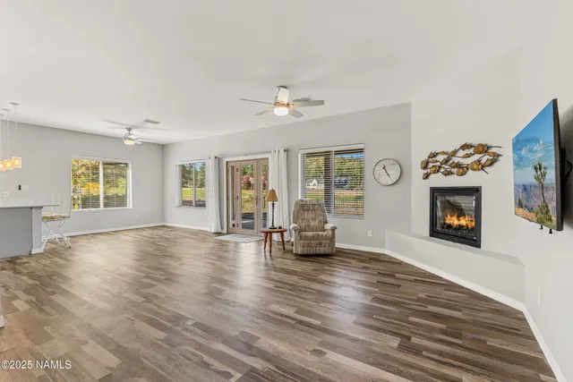 a view of an empty room with window and wooden floor