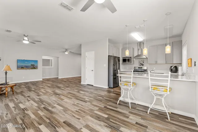 a view of a kitchen with kitchen island and stainless steel appliances