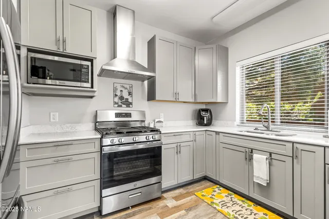 a kitchen with cabinets appliances and a window