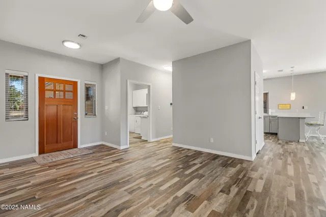 a view of a livingroom with wooden floor and a kitchen