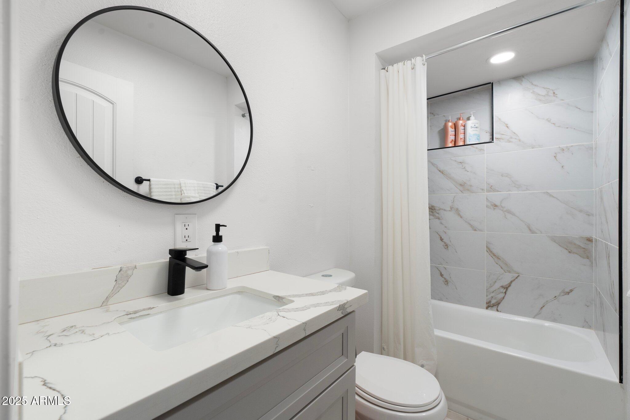 1759 North Spring Circle Mesa, AZ 85203 - Photo 45 of 69 a bathroom with a sink a toilet and a mirror