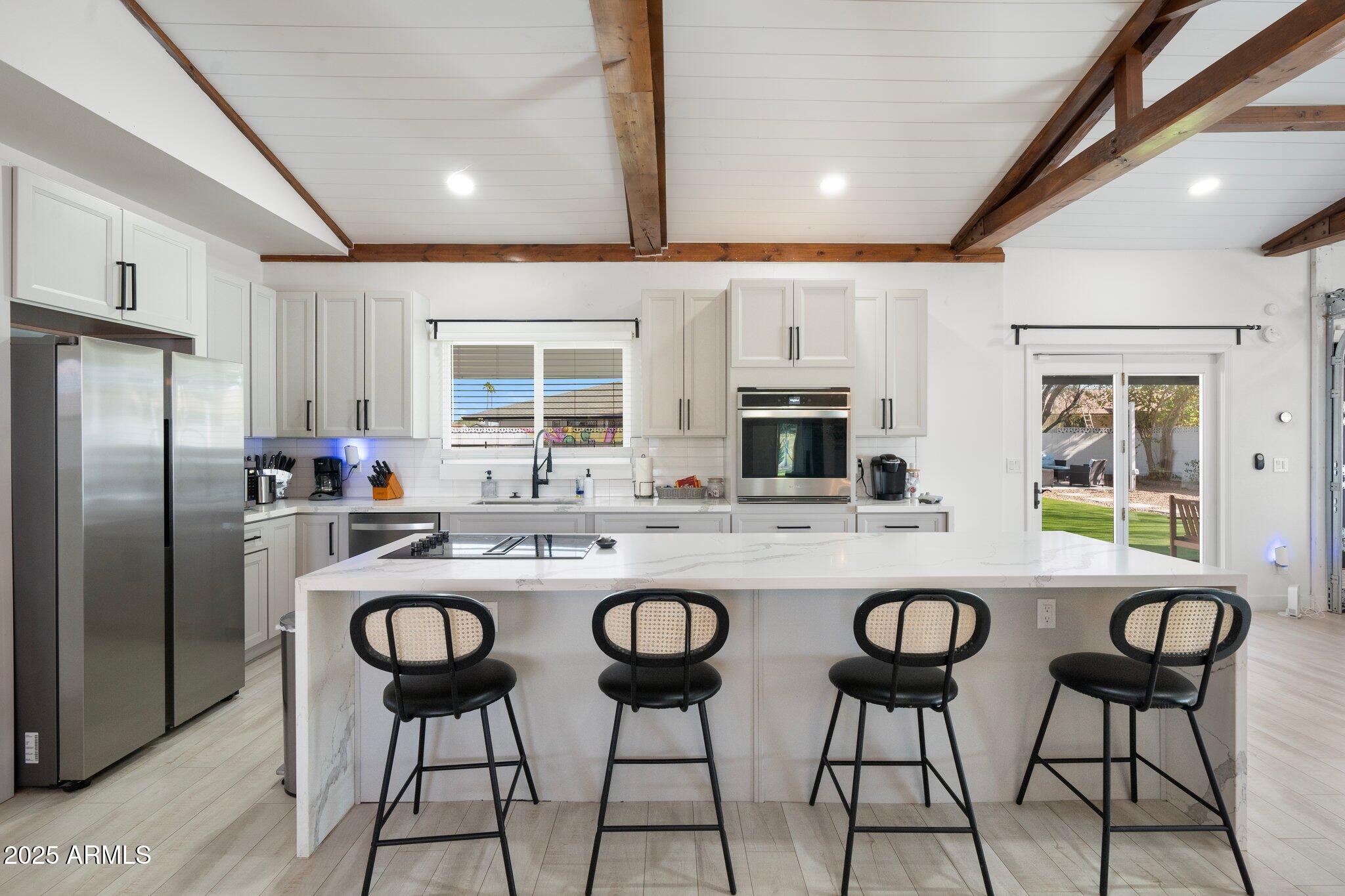 1759 North Spring Circle Mesa, AZ 85203 - Photo 61 of 69 a kitchen with stainless steel appliances granite countertop a table chairs microwave and refrigerator