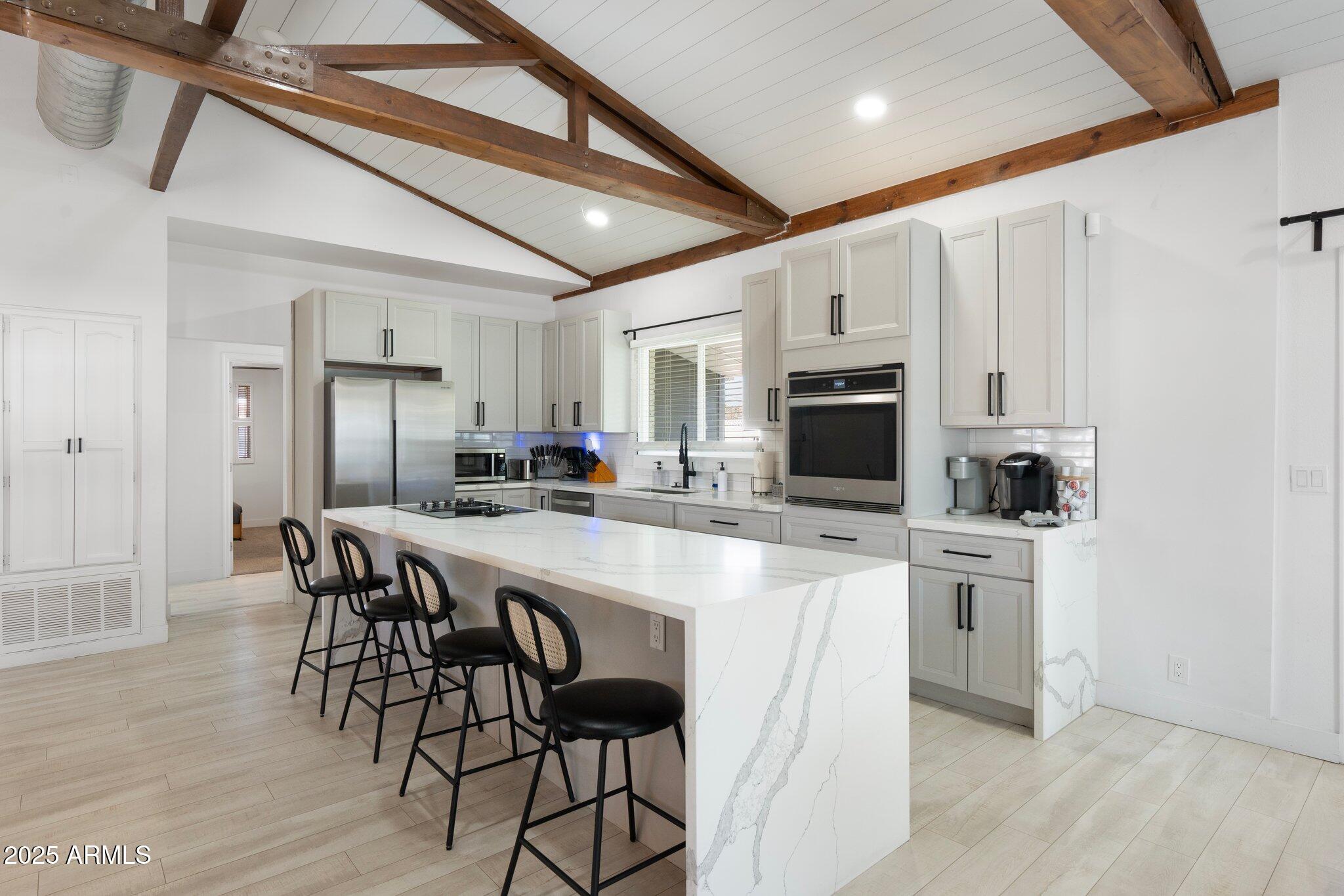 1759 North Spring Circle Mesa, AZ 85203 - Photo 63 of 69 a kitchen with stainless steel appliances a white table chairs and a refrigerator