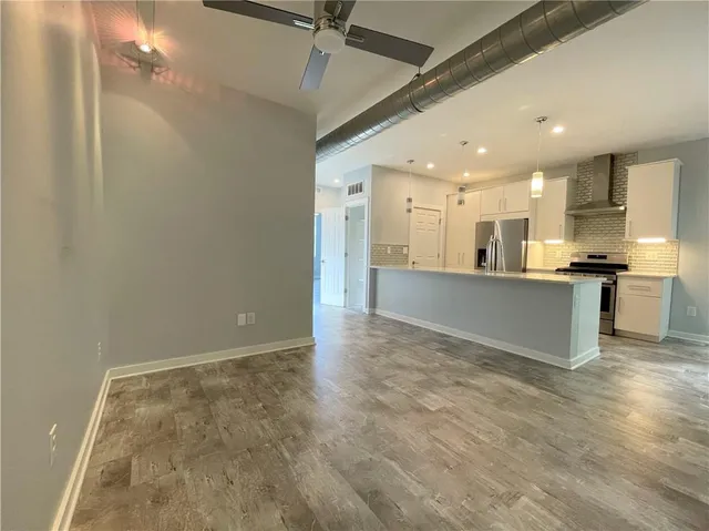 a view of kitchen with kitchen island stainless steel appliances refrigerator sink and cabinets