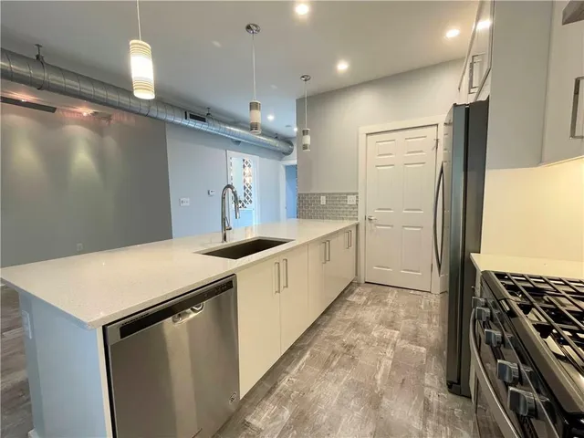 a kitchen with stainless steel appliances a refrigerator and a stove