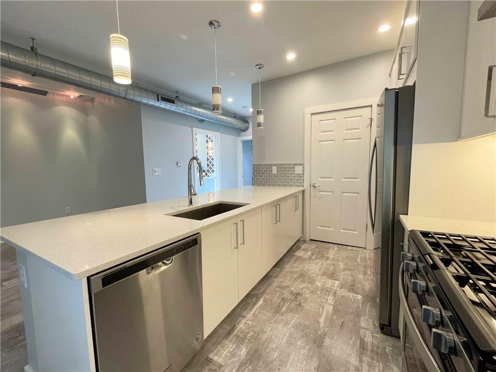 6026 Butler Street, Unit 3 Pittsburgh, PA 15201 - Photo 3 of 6 a kitchen with stainless steel appliances a refrigerator and a stove