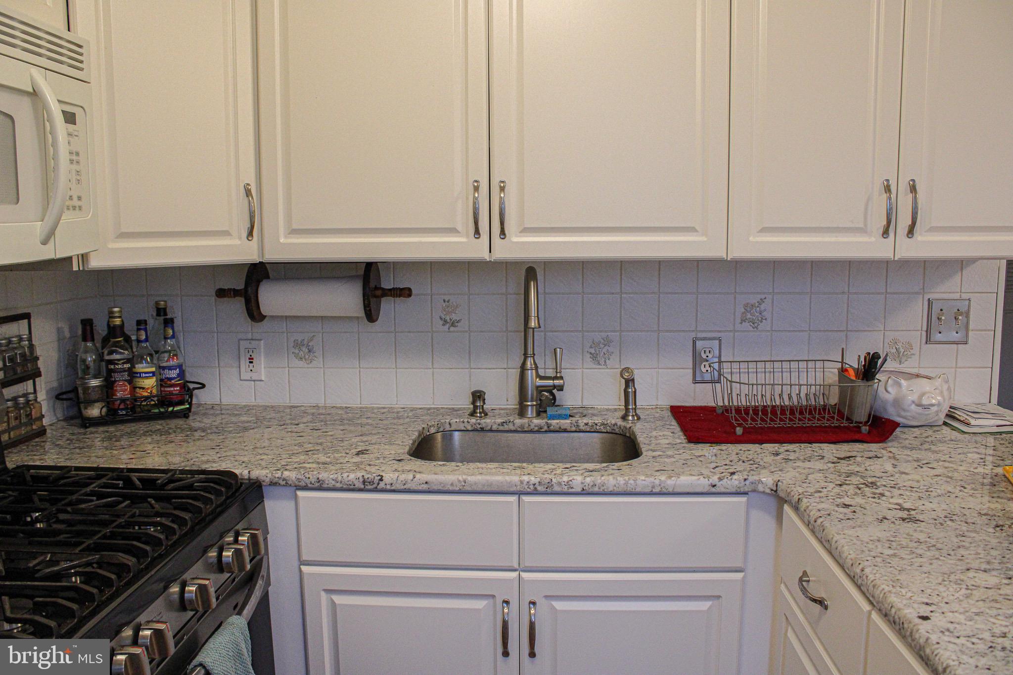 10830 Perrin Road Philadelphia, PA 19154 - Photo 10 of 24 a kitchen with granite countertop white cabinets and stainless steel appliances
