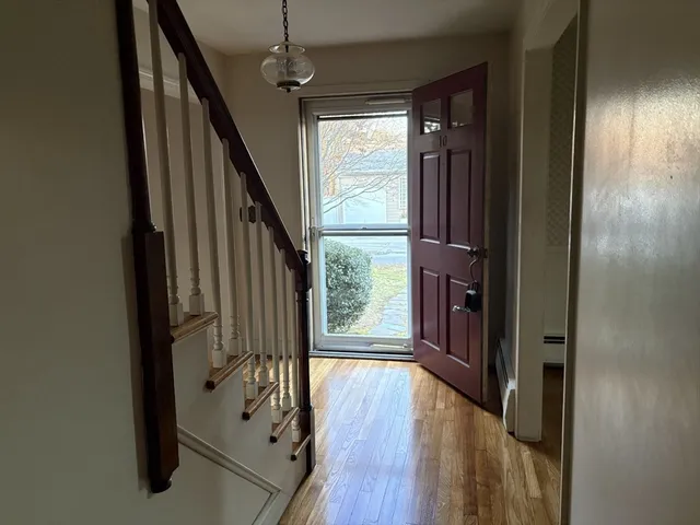 a view of an empty room with glass door and wooden floor