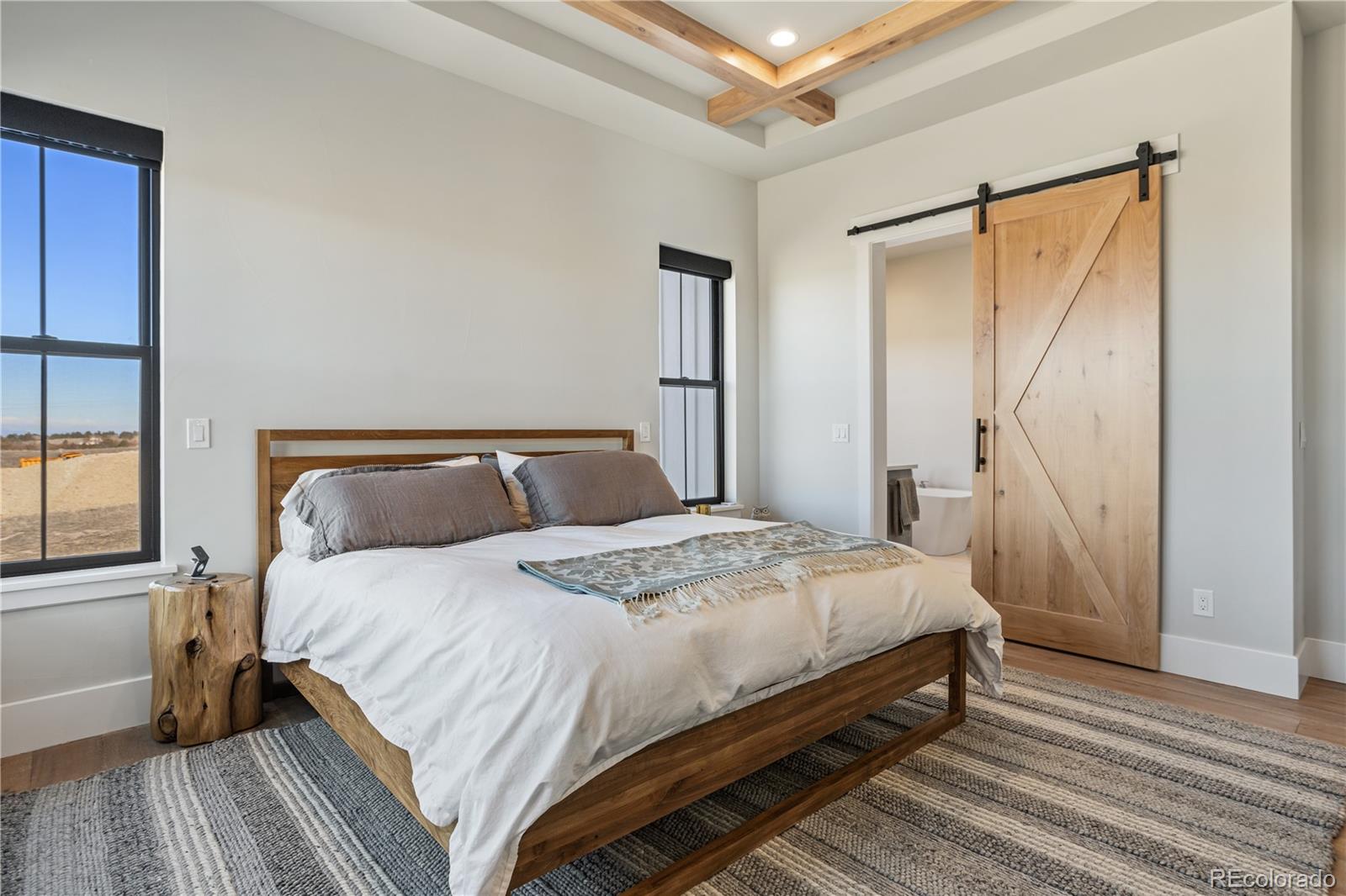 10621 Lone Fox Road Franktown, CO 80116 - Photo 22 of 50 a bedroom with a bed and wooden floor