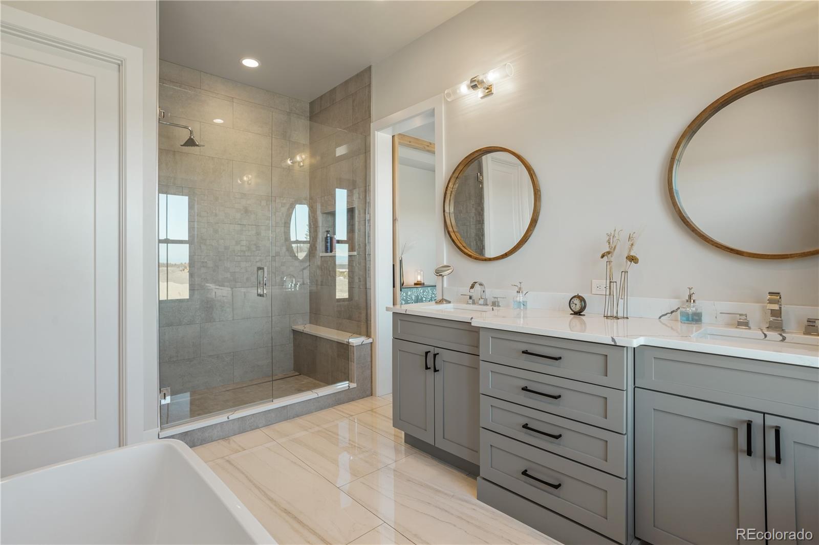 10621 Lone Fox Road Franktown, CO 80116 - Photo 27 of 50 a bathroom with a double vanity sink mirror and shower