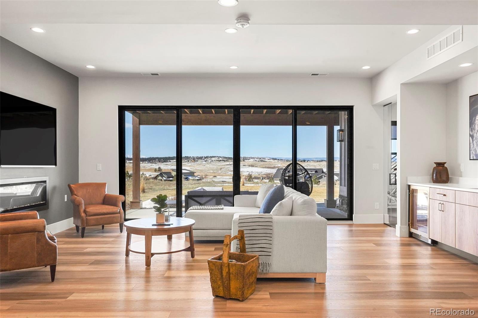 10621 Lone Fox Road Franktown, CO 80116 - Photo 35 of 50 a living room with fireplace furniture and a flat screen tv