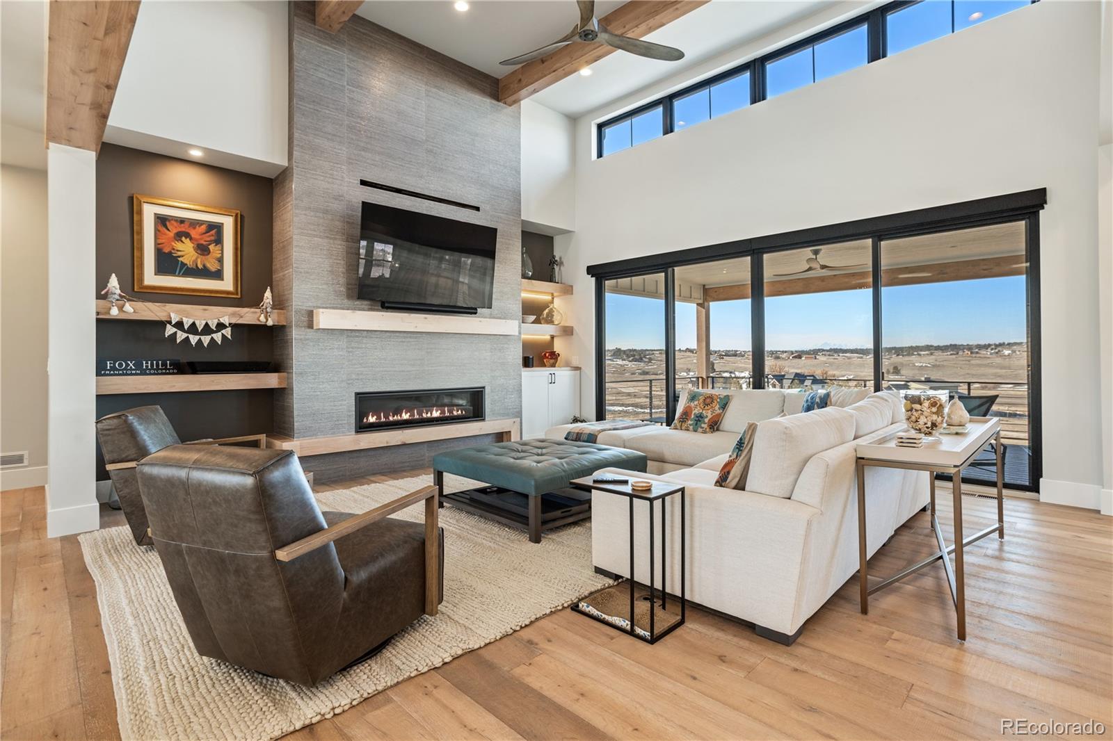 10621 Lone Fox Road Franktown, CO 80116 - Photo 7 of 50 a living room with furniture fireplace and a flat screen tv