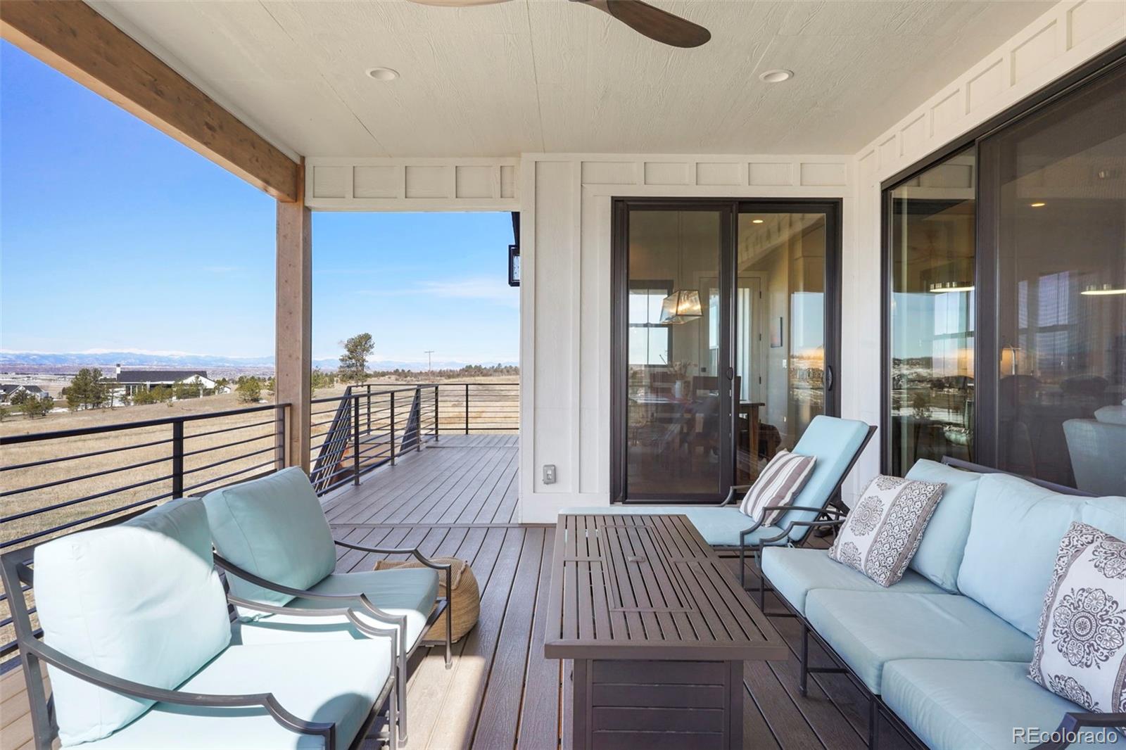 10621 Lone Fox Road Franktown, CO 80116 - Photo 9 of 50 a living room with furniture floor to ceiling window and wooden floor