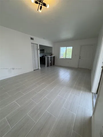 an empty room with windows & cabinet