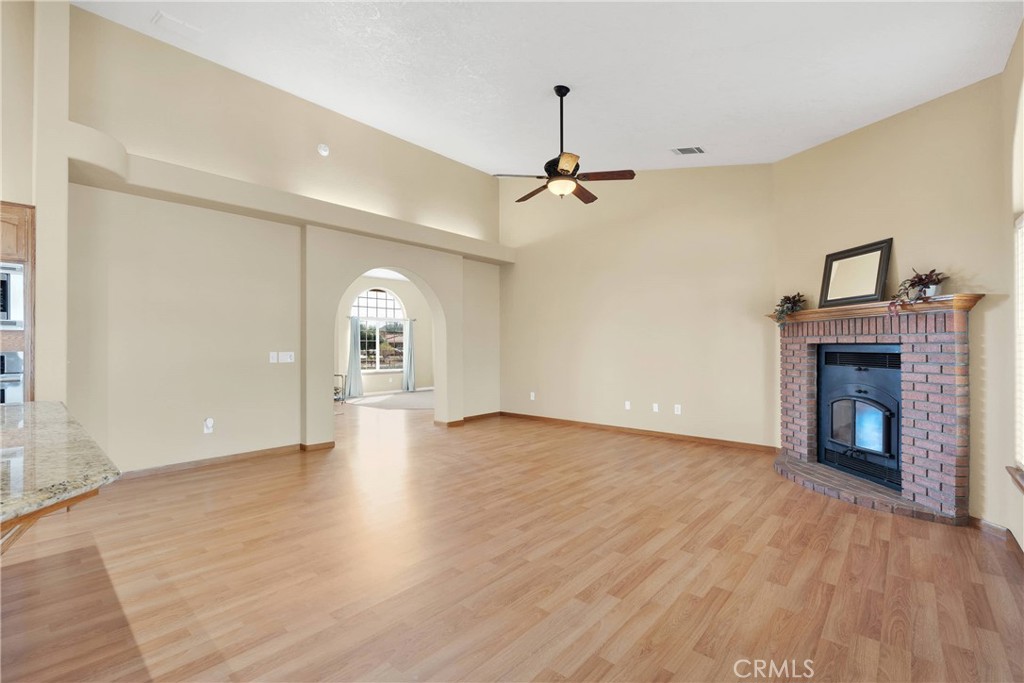 19501 Kinai Road Apple Valley, CA 92307 - Photo 12 of 69 a view of empty room with wooden floor and fireplace