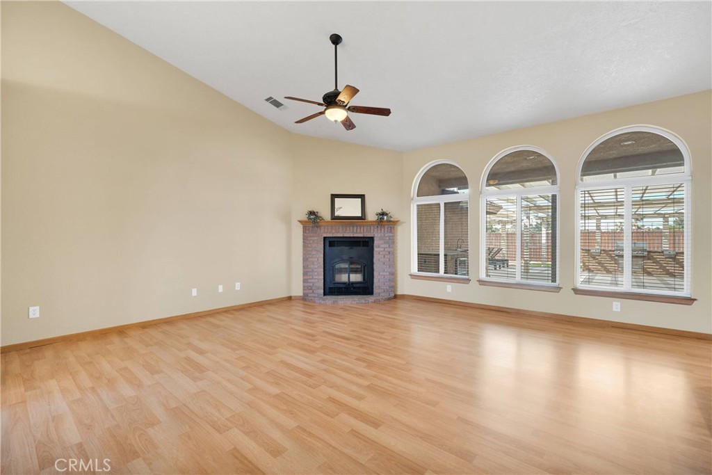 19501 Kinai Road Apple Valley, CA 92307 - Photo 13 of 69 a view of a livingroom with wooden floor a ceiling fan and windows