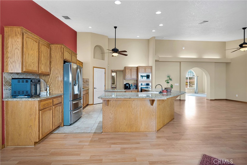 19501 Kinai Road Apple Valley, CA 92307 - Photo 21 of 69 a large kitchen with stainless steel appliances kitchen island a large counter top and a wooden floors