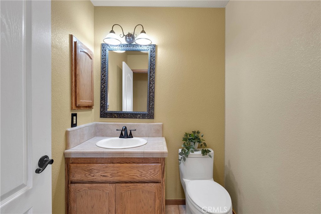 19501 Kinai Road Apple Valley, CA 92307 - Photo 26 of 69 a bathroom with a granite countertop sink and a mirror with toilet