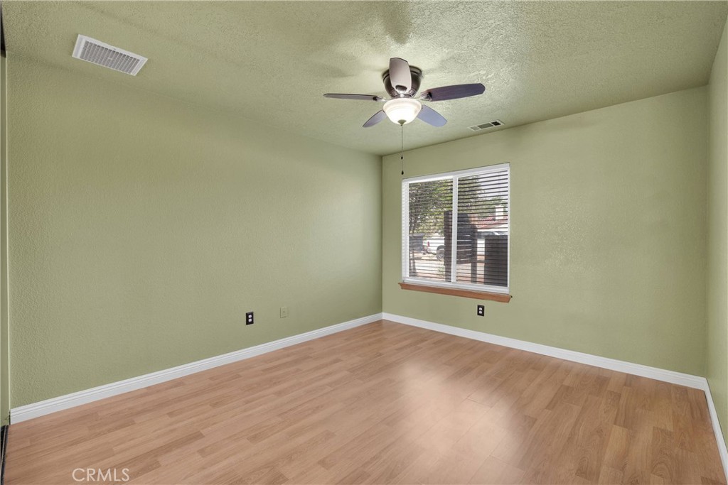 19501 Kinai Road Apple Valley, CA 92307 - Photo 28 of 69 a view of empty room with wooden floor and fan