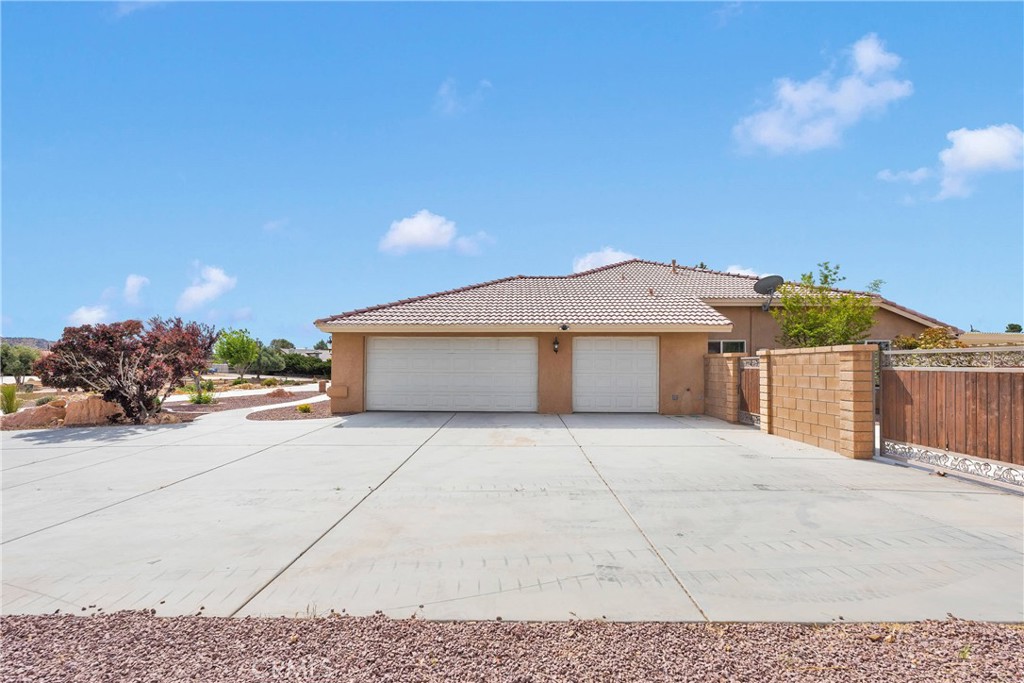19501 Kinai Road Apple Valley, CA 92307 - Photo 3 of 69 a front view of a house with a yard and garage