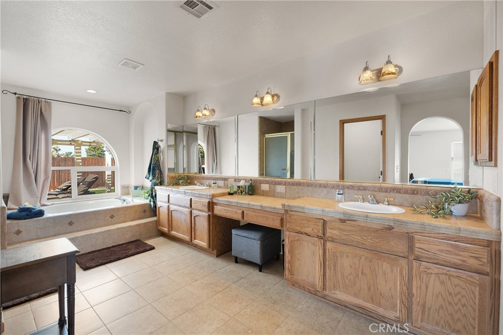 19501 Kinai Road Apple Valley, CA 92307 - Photo 40 of 69 a large bathroom with a lot of double vanity sink and mirror with bathtub