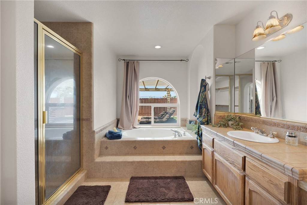 19501 Kinai Road Apple Valley, CA 92307 - Photo 41 of 69 a bathroom with a tub a sink and a large mirror