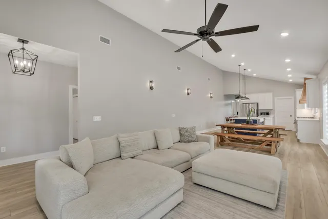 a kitchen with stainless steel appliances kitchen island granite countertop a sink dishwasher a stove a refrigerator a kitchen island with wooden cabinets and floor