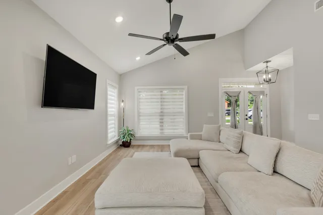 a living room with furniture kitchen view and a window